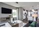 Cozy living room with modern furniture, a mounted TV, and a view of the kitchen at 357 Fosterton Cottage Way, Raleigh, NC 27603