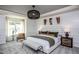 Bright main bedroom with white wainscoting, modern light fixture, and an accent chair by the window at 357 Fosterton Cottage Way, Raleigh, NC 27603