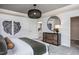 This bright main bedroom has white wainscoting, a modern light fixture, and rustic wood-themed decor at 357 Fosterton Cottage Way, Raleigh, NC 27603