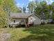 Wide view of the backyard with the house, wooden deck, and shed in view at 359 Punch Hill Farm Rd, Rougemont, NC 27572