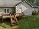 Backyard wooden deck with metal chairs, greenery, and access to the house at 359 Punch Hill Farm Rd, Rougemont, NC 27572
