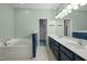 Bathroom with double sinks, soaking tub, and decorative mirror at 359 Punch Hill Farm Rd, Rougemont, NC 27572