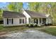 A cozy, single-story home with tan siding, dark shutters, and a charming front porch at 359 Punch Hill Farm Rd, Rougemont, NC 27572