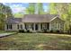 Charming single-story home featuring a stone facade, covered porch, and well-maintained landscaping at 359 Punch Hill Farm Rd, Rougemont, NC 27572