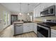 Well-lit kitchen featuring stainless steel appliances, white cabinetry, and an eat-in dining area at 359 Punch Hill Farm Rd, Rougemont, NC 27572