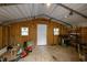 The interior of a small outbuilding featuring wooden walls and a white door, offering versatile storage space at 359 Punch Hill Farm Rd, Rougemont, NC 27572
