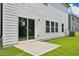 A well-maintained backyard featuring a concrete patio, expansive lawn, and sliding glass doors at 3841 Rosebush Dr, Zebulon, NC 27597