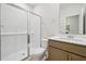 This bathroom features a sliding glass shower door, white subway tile, and wood-tone vanity at 3841 Rosebush Dr, Zebulon, NC 27597