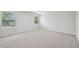 A second floor carpeted bedroom with neutral walls and two large windows overlooking the front yard at 3841 Rosebush Dr, Zebulon, NC 27597
