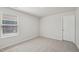 A bedroom features neutral carpet, a window with blinds and a white door at 3841 Rosebush Dr, Zebulon, NC 27597