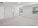 Primary bedroom featuring neutral carpet and paint, two windows, and attached bathroom at 3841 Rosebush Dr, Zebulon, NC 27597