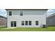 Rear exterior view of home highlighting light siding, windows, and well-maintained lawn at 3841 Rosebush Dr, Zebulon, NC 27597