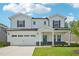 Charming two-story home with a two car garage, landscaped yard, and inviting covered front porch at 3841 Rosebush Dr, Zebulon, NC 27597