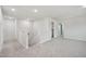 A carpeted hallway features neutral paint, white trim, and a view into the laundry room at 3841 Rosebush Dr, Zebulon, NC 27597