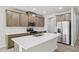 Modern kitchen with stainless steel appliances and a large island with quartz countertop at 3841 Rosebush Dr, Zebulon, NC 27597
