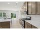 Modern kitchen with stainless steel appliances, a quartz countertop, and a view to the living room at 3841 Rosebush Dr, Zebulon, NC 27597