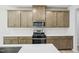 Modern kitchen with stainless steel oven, quartz countertops, wood cabinetry, and mosaic backsplash at 3841 Rosebush Dr, Zebulon, NC 27597