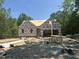 Framing of a new home with wood stacked on the lot, featuring a sunny, wooded background at 42 Ponchartrain St, Fuquay Varina, NC 27526
