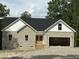 Stone and siding new construction home featuring a black roof and an attached two car garage at 42 Ponchartrain St, Fuquay Varina, NC 27526