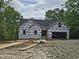 New construction with dark roof and house wrap on a large lot with trees at 42 Ponchartrain St, Fuquay Varina, NC 27526