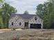New construction with dark roof and house wrap on a large lot with trees at 42 Ponchartrain St, Fuquay Varina, NC 27526