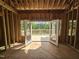 Unfinished living room showing view of the deck, surrounding trees and open space from the sliding glass doors at 42 Ponchartrain St, Fuquay Varina, NC 27526