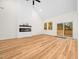 Bright living room featuring wood floors, a modern fireplace, vaulted ceilings, and sliding glass doors to the deck at 42 Ponchartrain St, Fuquay Varina, NC 27526