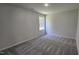 This bedroom has neutral colored walls and carpet, a window, and base trim at 427 Magnolia Run Way, Benson, NC 27504