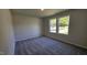 This bedroom has neutral colored walls and carpet with two windows looking to the exterior at 427 Magnolia Run Way, Benson, NC 27504