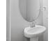 A pedestal sink with a round mirror is the focal point of this half bathroom at 43 Pansy Park # 233, Clayton, NC 27520