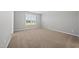 A neutral-colored bedroom is brightly lit with a window offering outdoor views at 43 Pansy Park # 233, Clayton, NC 27520