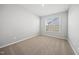 A simple, carpeted bedroom offers a window with backyard views and ample space at 43 Pansy Park # 233, Clayton, NC 27520