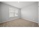 Bedroom with neutral carpet and paint, with a window providing natural light at 43 Pansy Park # 233, Clayton, NC 27520