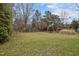 Expansive backyard featuring a well-maintained lawn, mature trees, and perimeter fencing at 4318 Peachway Dr, Durham, NC 27705