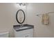 Half bath with granite countertop, white cabinet, updated fixtures, and a decorative mirror at 4318 Peachway Dr, Durham, NC 27705