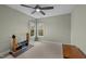 Bright bedroom with neutral carpet and walls, ceiling fan, and a view of the outdoors at 4318 Peachway Dr, Durham, NC 27705