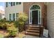 Elegant front entry with brick steps, black door, and decorative shrubbery at 4318 Peachway Dr, Durham, NC 27705