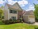 Charming two-story home with brick facade, black shutters, manicured lawn, and attached garage at 4318 Peachway Dr, Durham, NC 27705
