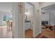 Hallway view of a half bath and living spaces with hardwood floors and neutral paint at 4318 Peachway Dr, Durham, NC 27705