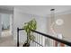 Staircase with a modern light fixture, leading to the upper level, and a plant on the rail at 4318 Peachway Dr, Durham, NC 27705