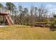 Beautiful backyard with green lawn and decorative shrubs near the deck stairs and tall trees at 437 Creekhurst Pl, Cary, NC 27519