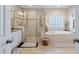 A tiled bathroom features a glass shower, a soaking tub, and a gray-patterned rug at 437 Creekhurst Pl, Cary, NC 27519