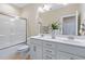 Bright bathroom with a double vanity, marble countertops, and shower/tub combo with glass doors at 437 Creekhurst Pl, Cary, NC 27519