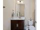 Small bathroom with a toilet, sink, framed mirror, and dark wood cabinet at 437 Creekhurst Pl, Cary, NC 27519