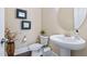 Stylish powder room featuring pedestal sink, decorative mirrors, and elegant fixtures at 437 Creekhurst Pl, Cary, NC 27519