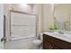 Bathroom with a shower-tub combo featuring glass doors and a white vanity at 437 Creekhurst Pl, Cary, NC 27519