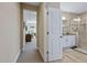 A hallway opens into a bathroom with a tiled shower and granite countertops at 437 Creekhurst Pl, Cary, NC 27519