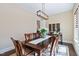 Dining room with dark wood table, white linens, modern lighting, and neutral walls at 437 Creekhurst Pl, Cary, NC 27519