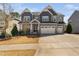 Beautiful two-story home with a three-car garage, stone accents, and well-manicured lawn at 437 Creekhurst Pl, Cary, NC 27519