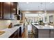 Modern kitchen featuring hardwood floors, large island, dark cabinets and direct access to living room at 437 Creekhurst Pl, Cary, NC 27519